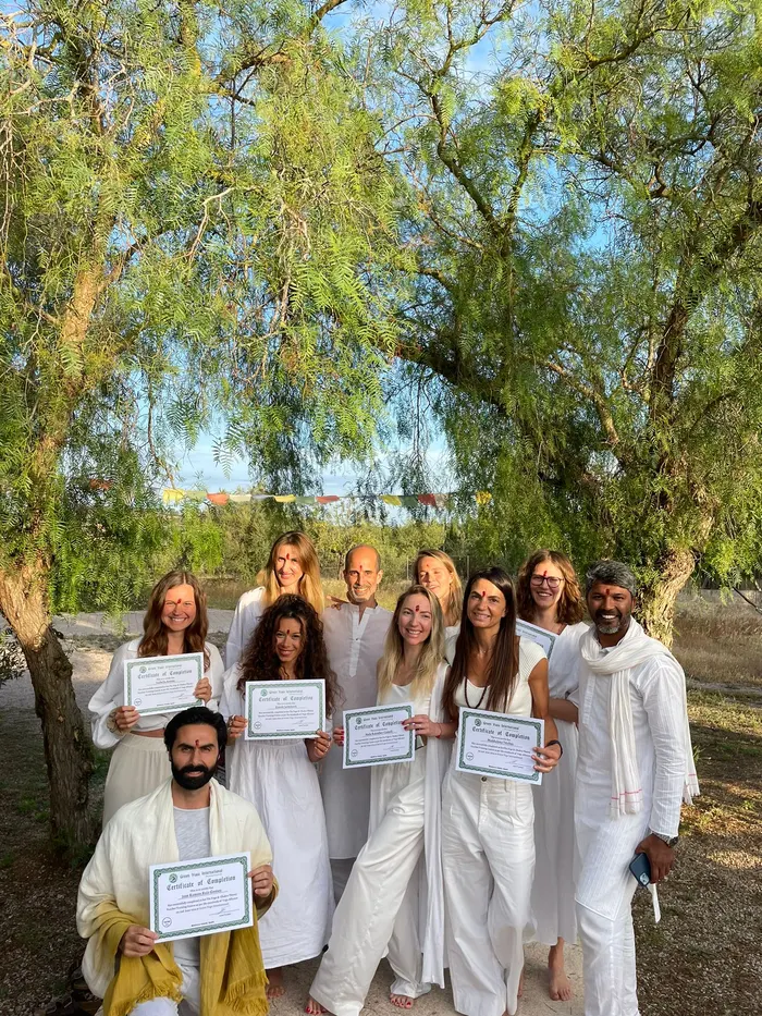 Group photo under the trees, holding certificates